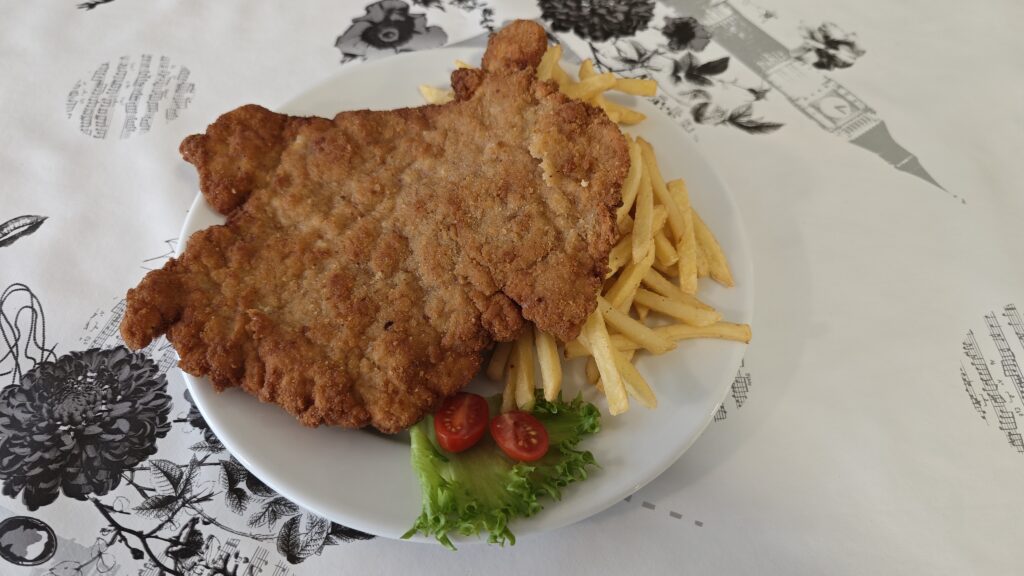Klasyczny, kultowy schabowy podany z frytkami, sałatą i pomidorkami koktajlowymi 